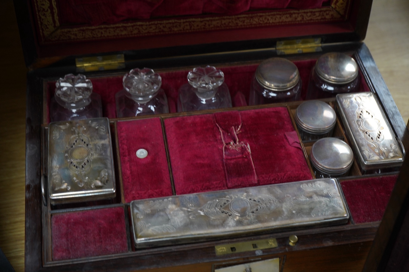 Three 19th century vanity and sewing boxes with fitted interiors to include a mother of pearl inlaid example with glass bottles, jars and mirror, largest 35cm wide. Condition - fair, some losses